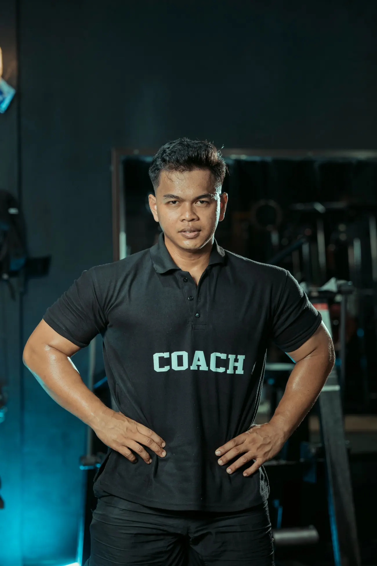 Portrait du coach dans sa salle, bras croisés