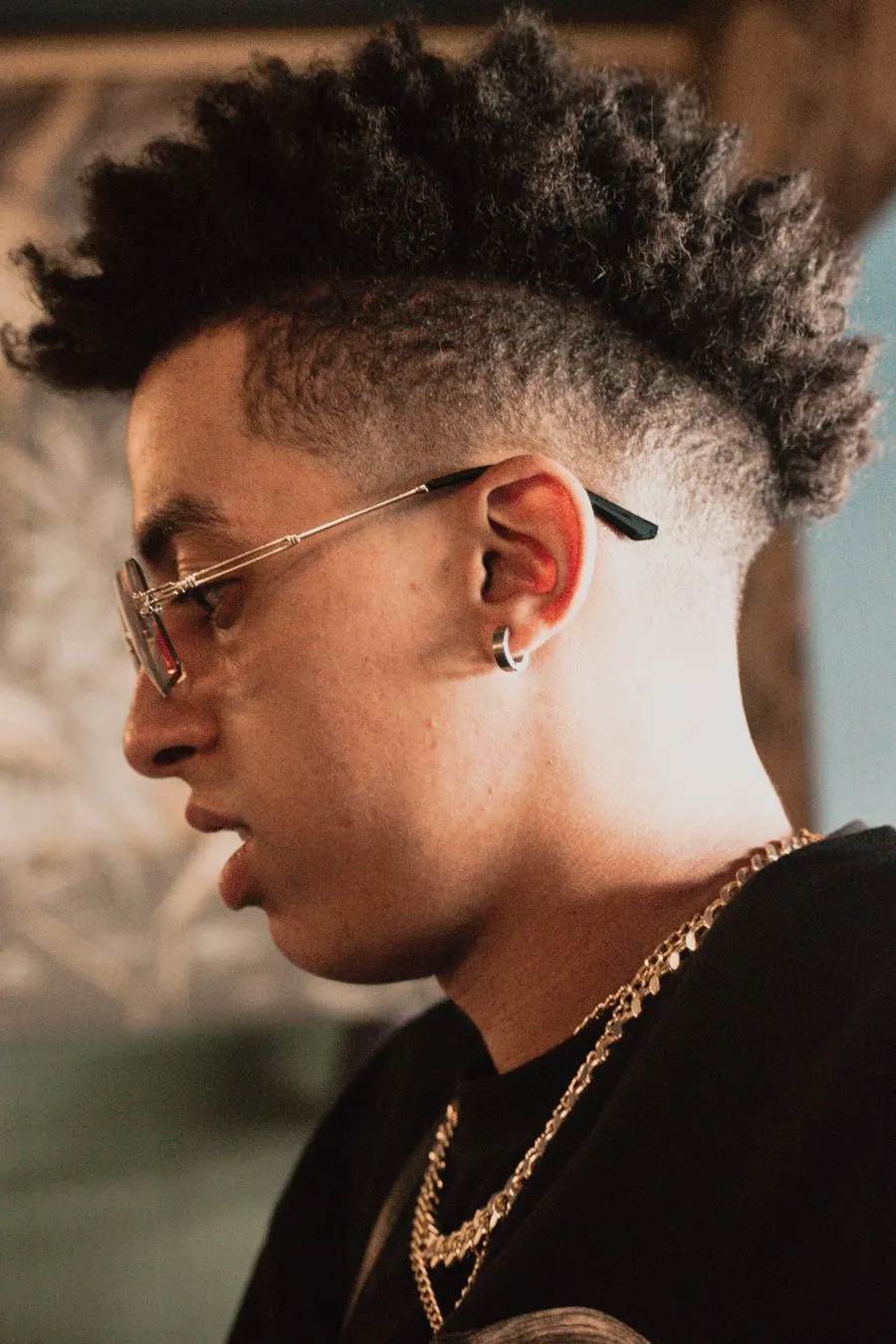 Burst fade arrondi autour de l’oreille, boucles sur le dessus