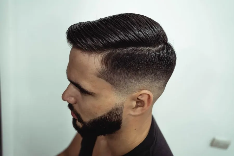 Mid fade avec raie marquée et dessus coiffé sur le côté