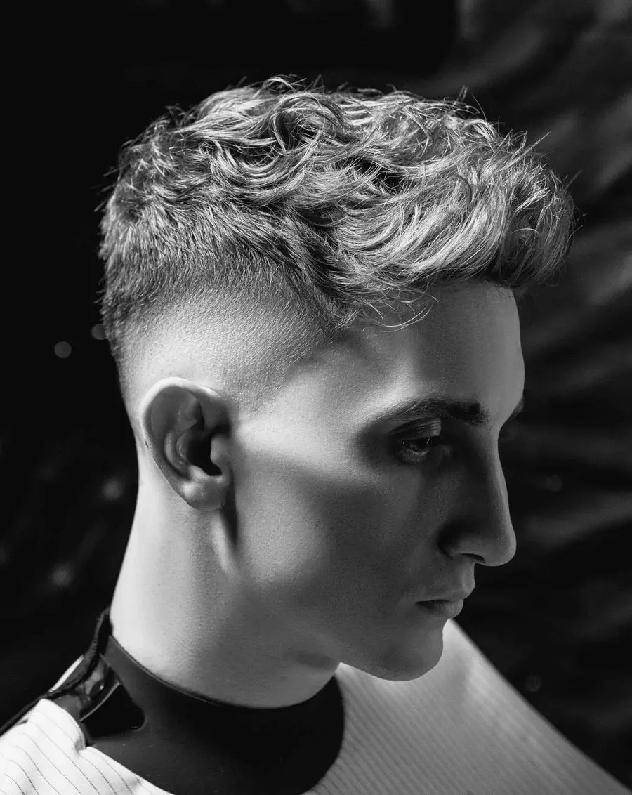 Skin fade à blanc sur les côtés, dessus bouclé, portrait studio en noir et blanc