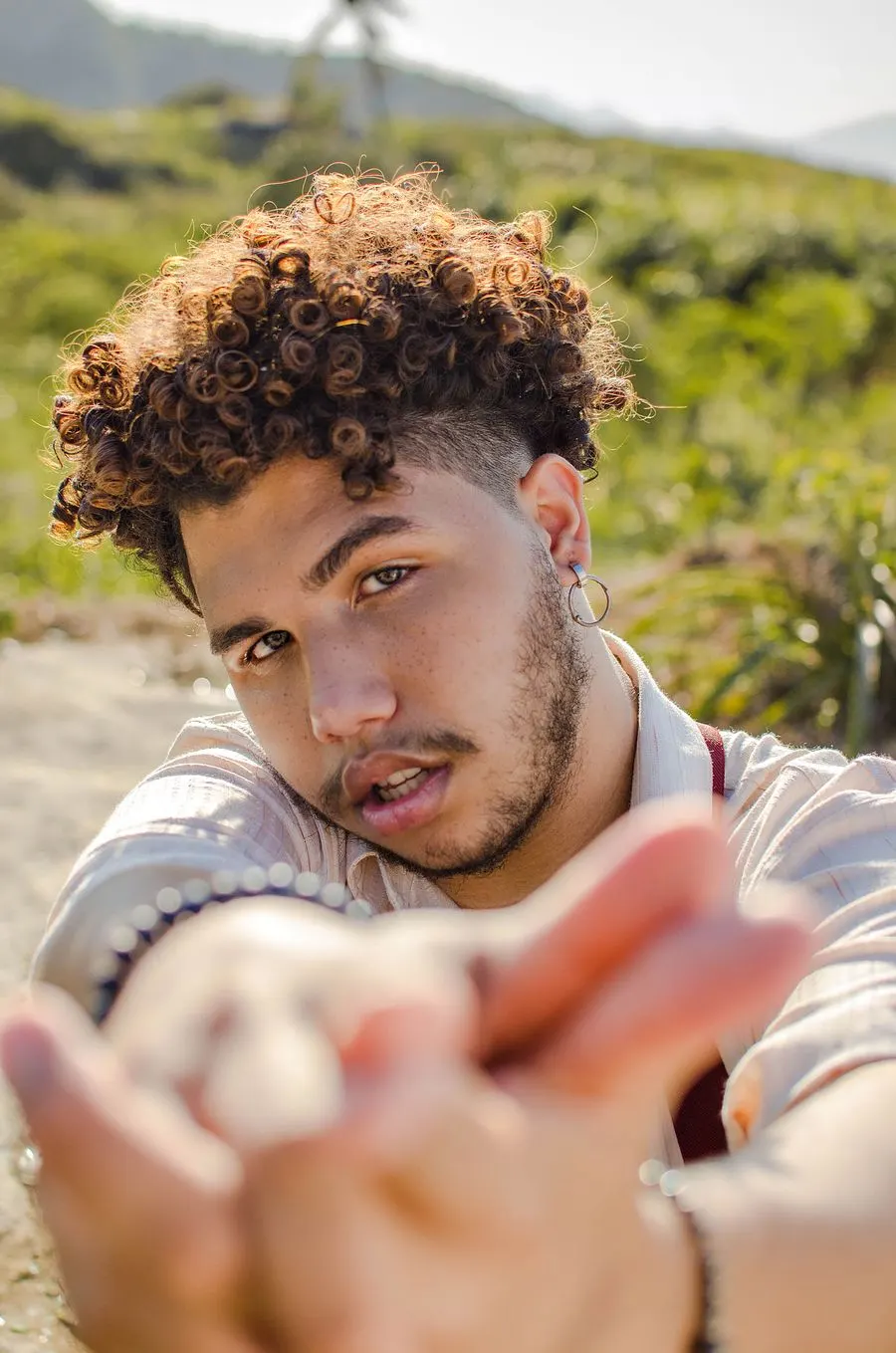 Curly fade : boucles sur le dessus, côtés dégradés