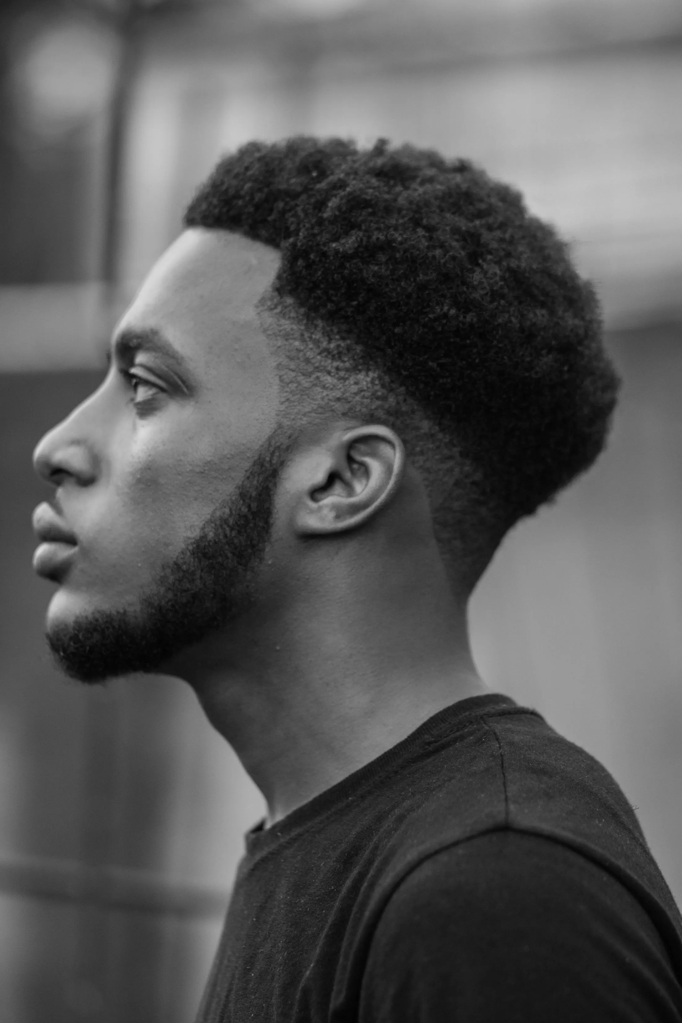 Profil d’un homme en noir et blanc : dégradé net sur les tempes et la nuque, contours précis, cheveux crépus texturés sur le dessus
