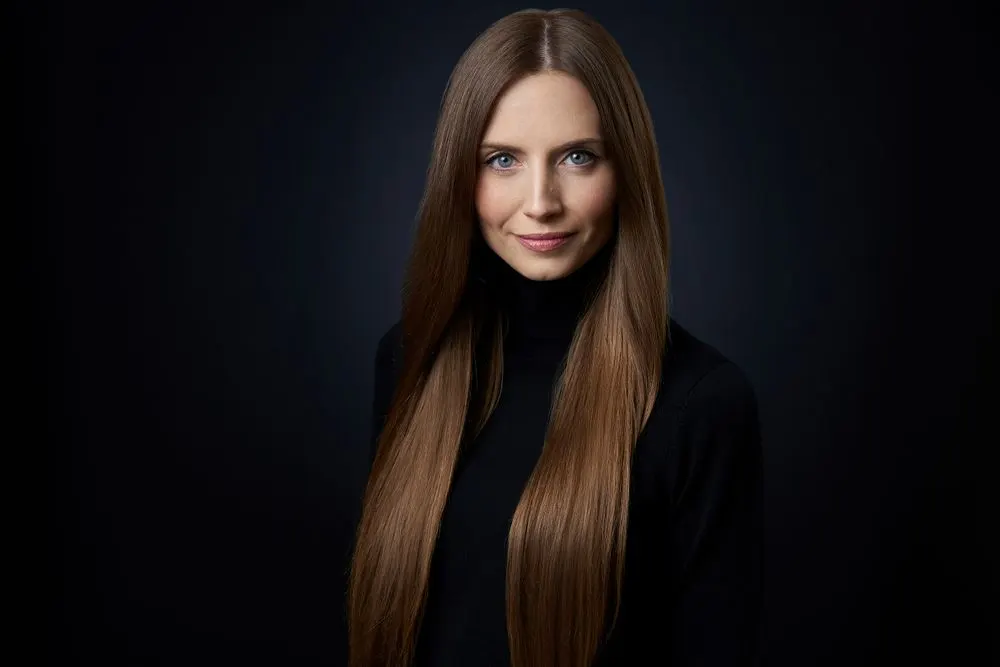 Longs cheveux châtains lisses et brillants sur un pull noir