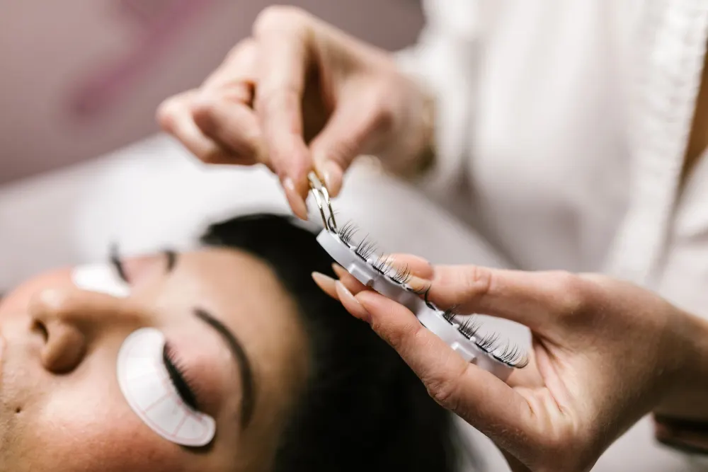 Pose d’extensions de cils sur une cliente allongée