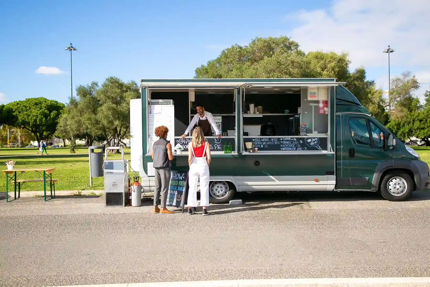 Le camion ouvert sur le trottoir avec des clients qui attendent leur commande