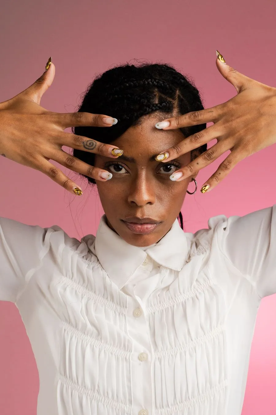 Portrait de Léa, les mains encadrant son visage, ongles décorés