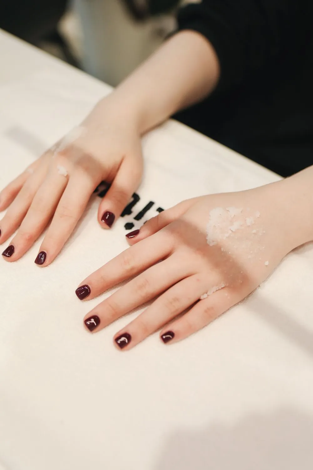 Ongles courts bordeaux sur une table claire