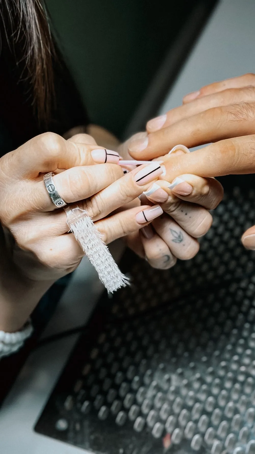 La nail artist trace un motif au pinceau fin