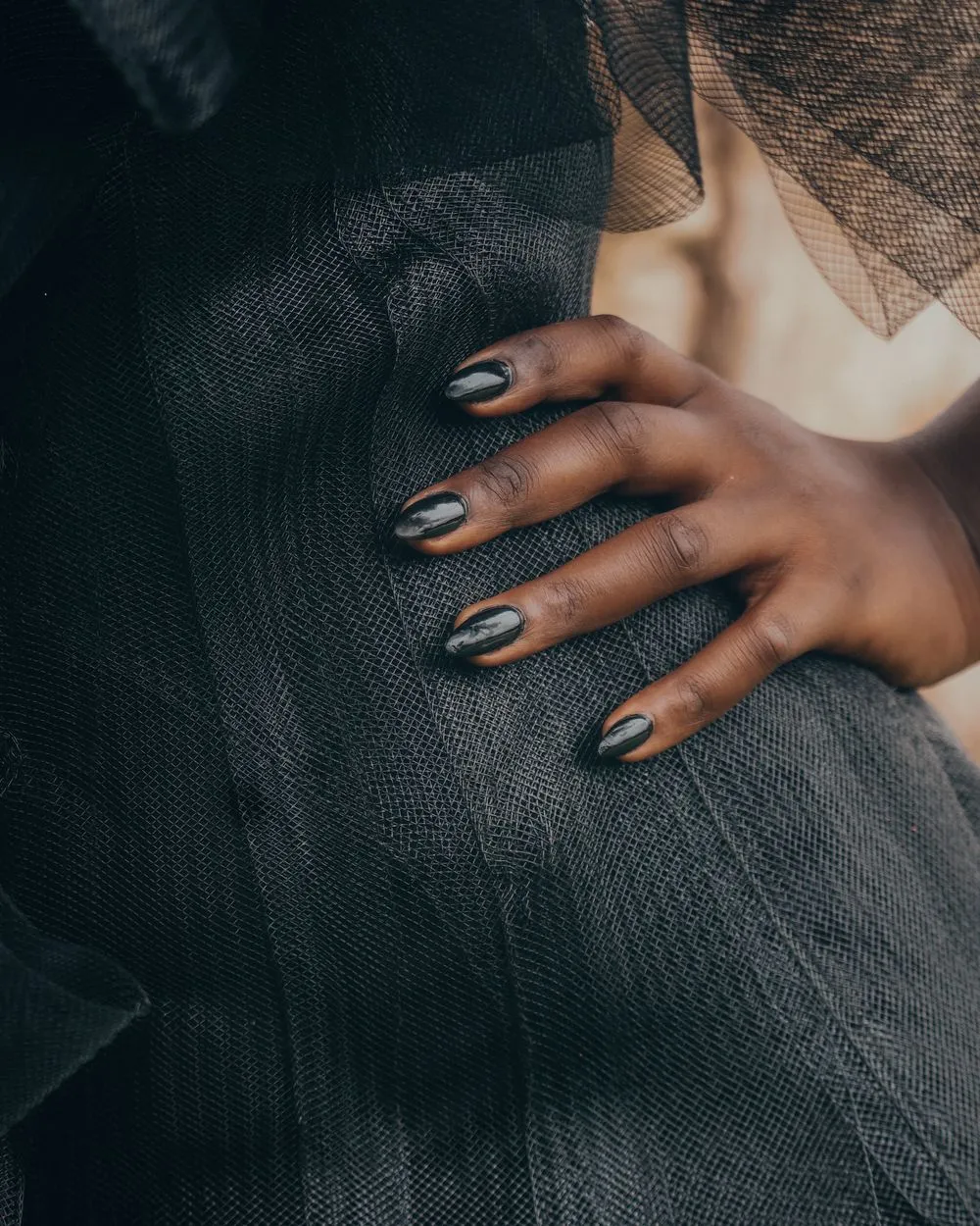 Ongles effet métal fumé sur une veste en tweed sombre