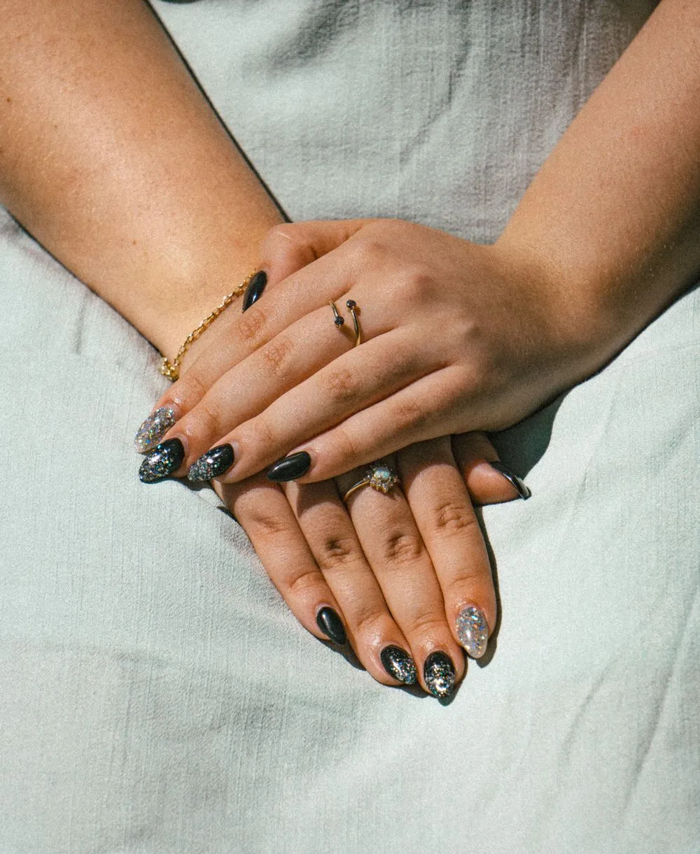 Nail art noir et argent, mains baguées
