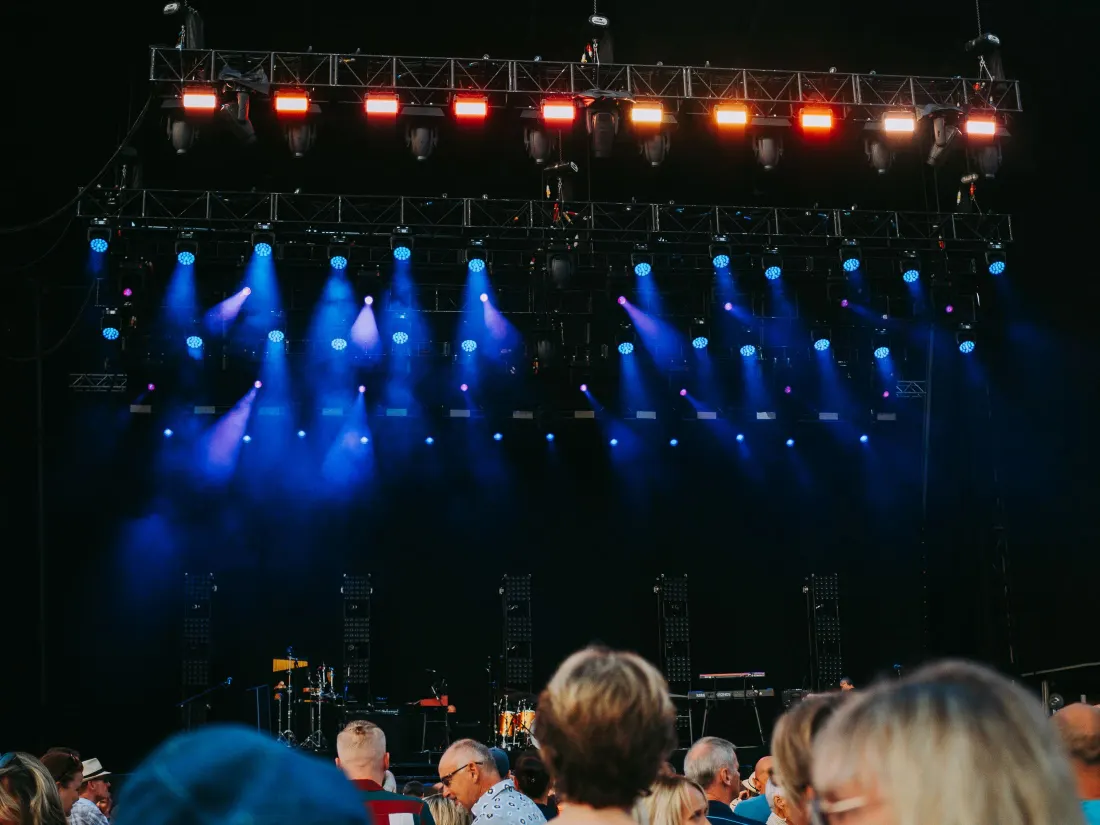 Scène de festival éclairée en bleu au-dessus du public