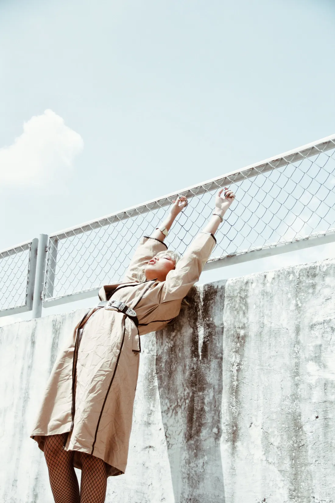Mannequin en trench appuyé sur un mur de béton