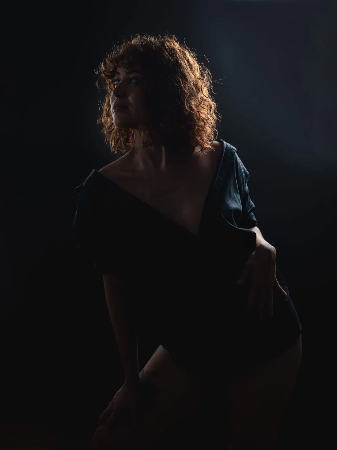 Portrait de femme dans une lumière rasante, fond sombre