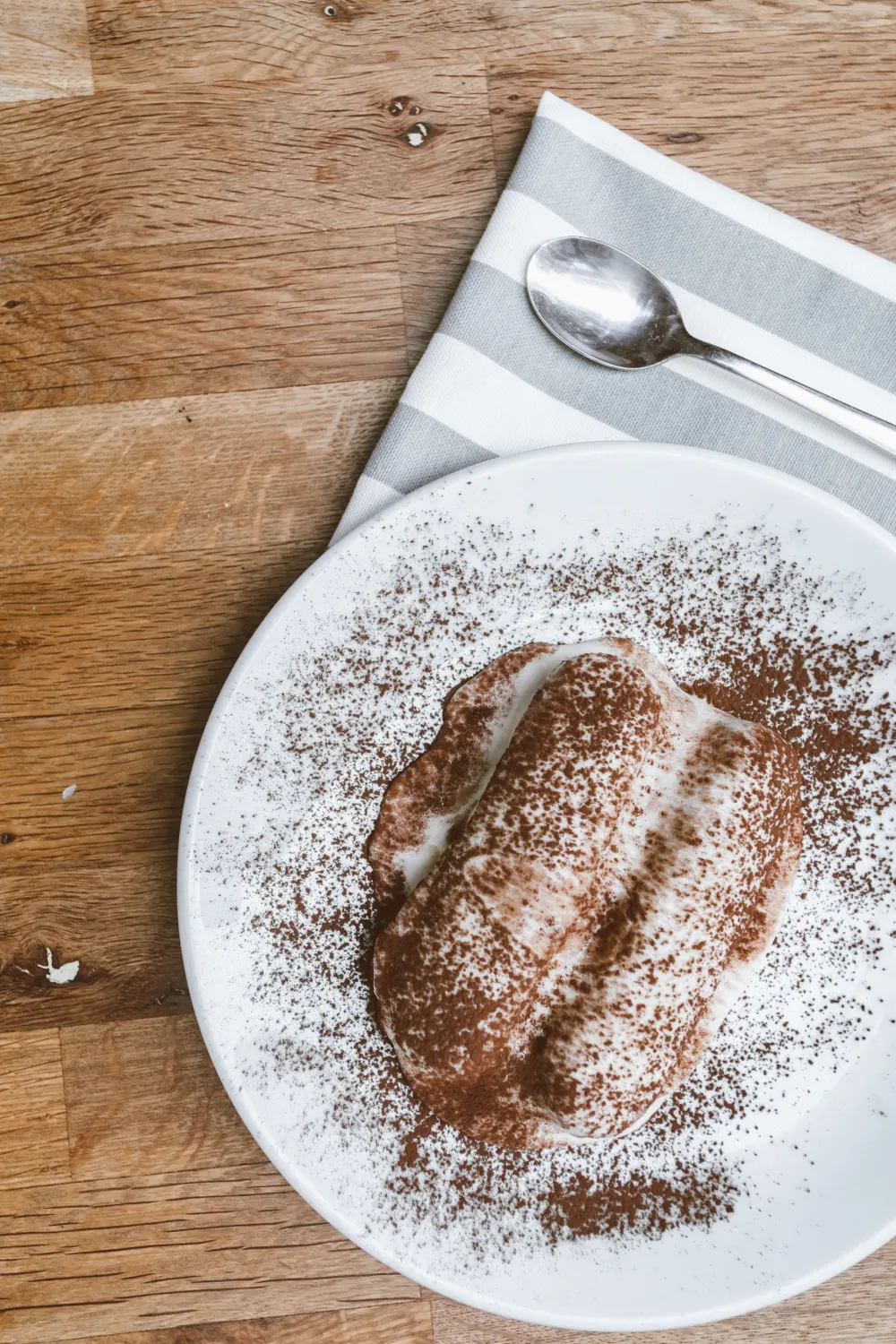 Tiramisù saupoudré de cacao sur une assiette
