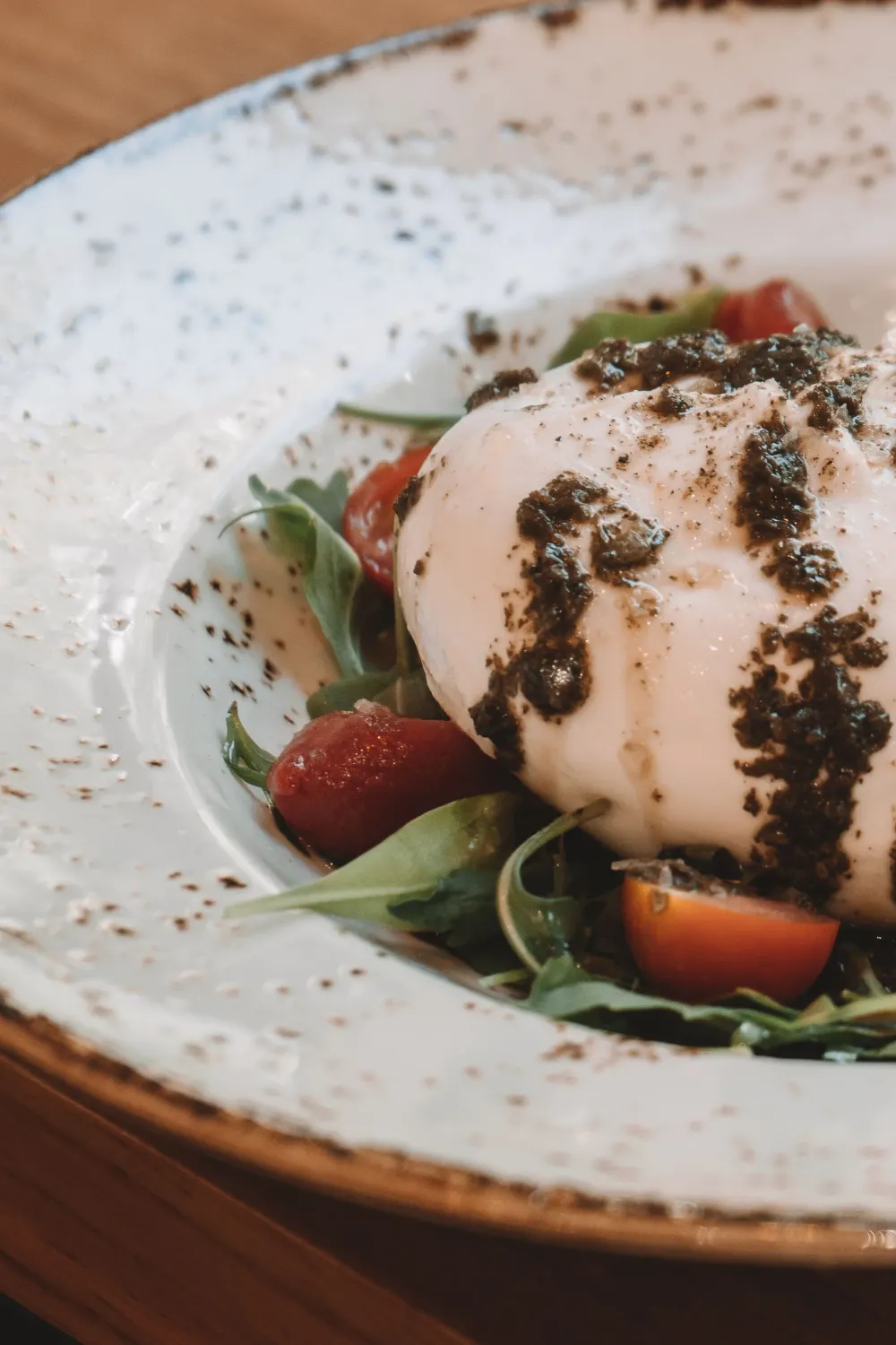 Burrata entière sur lit de roquette et tomates cerises