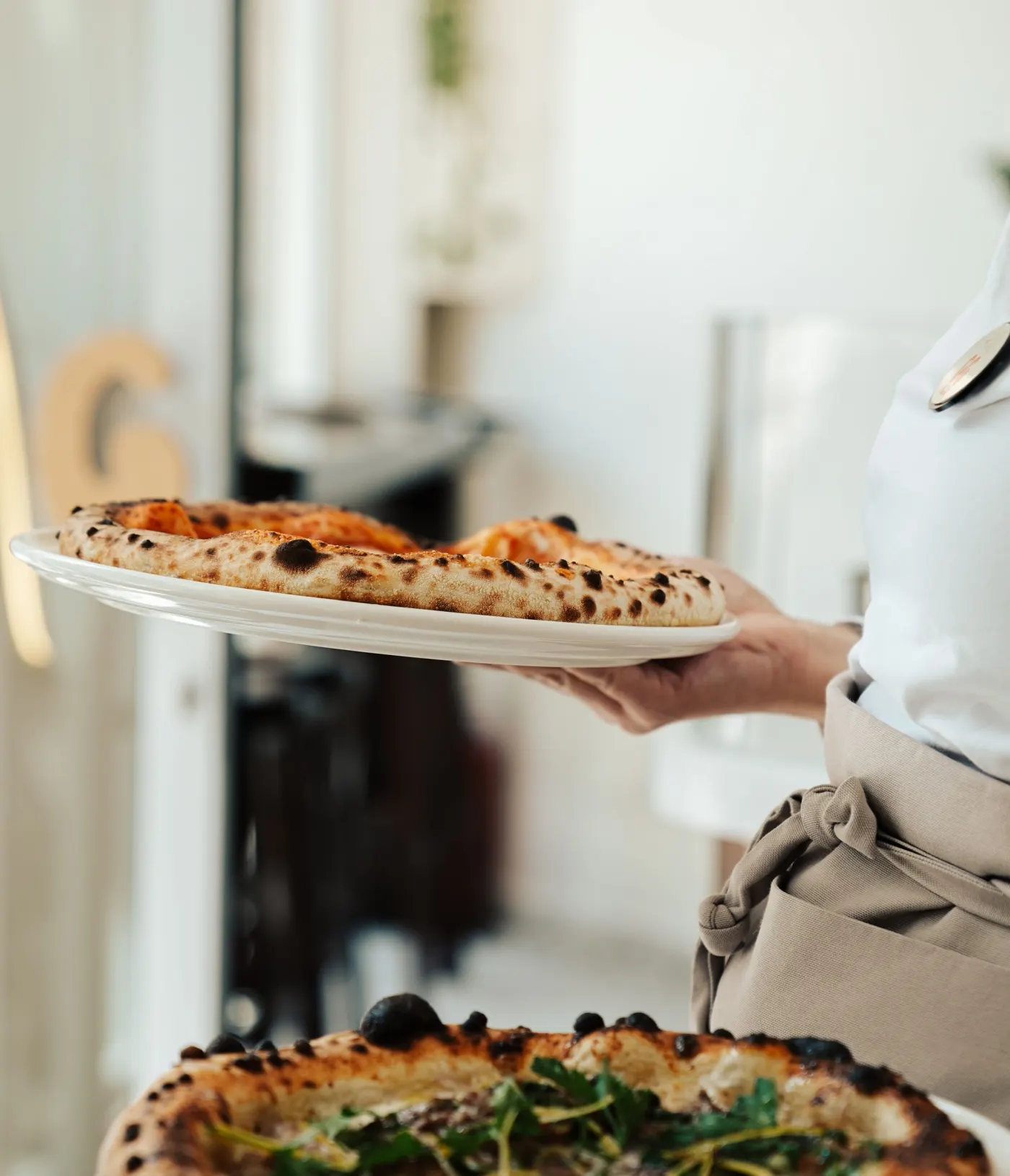 Serveur qui présente une pizza tout juste sortie du four