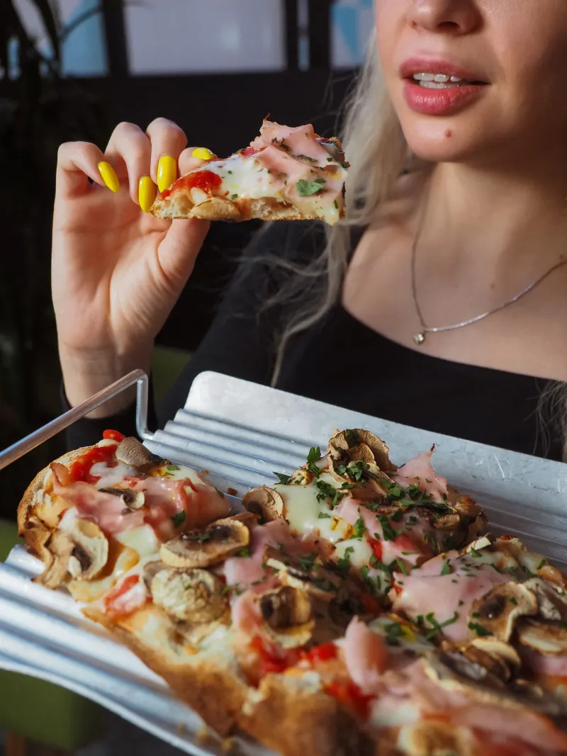 Cliente qui croque une part de pizza