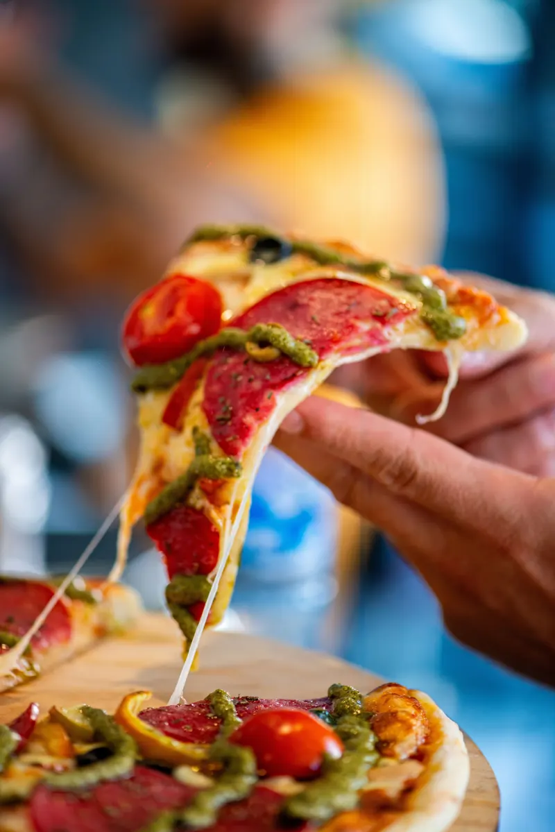 Part de pizza soulevée, fromage filant