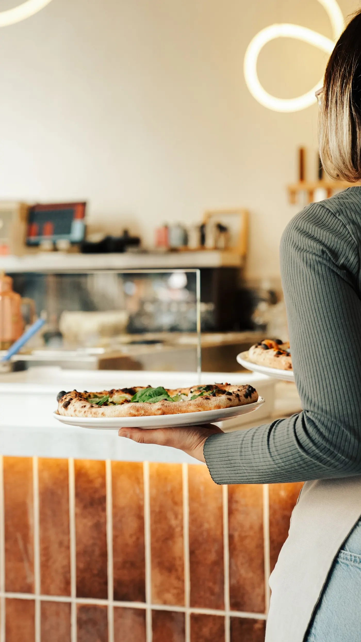 Serveuse qui apporte une pizza en salle