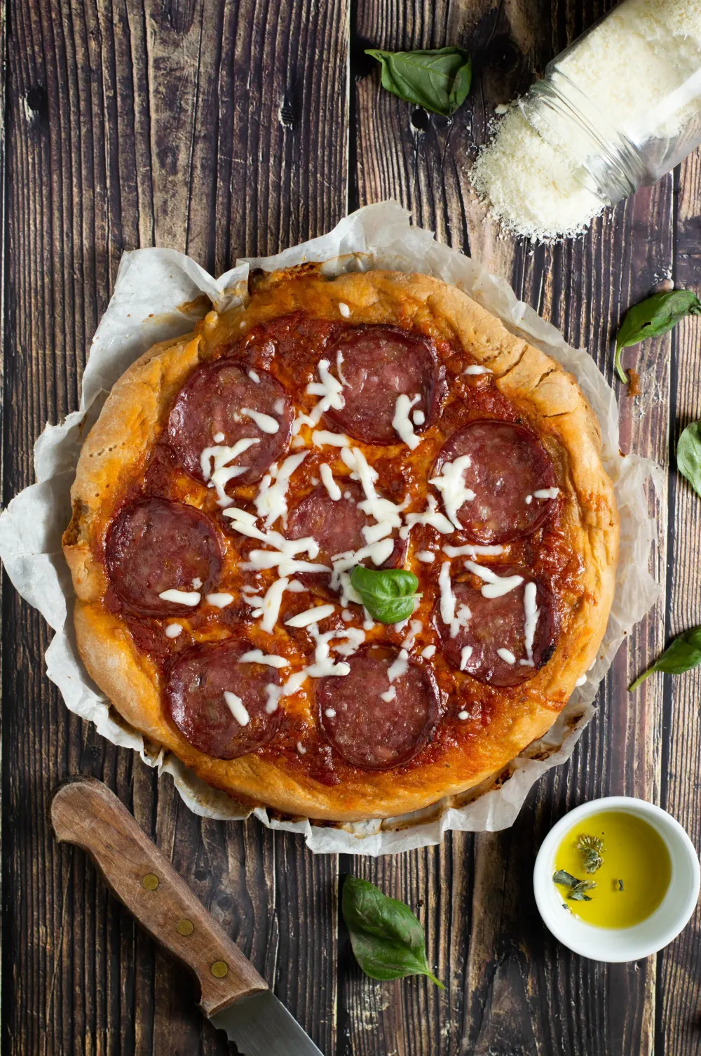 Pizza diavola au salami piquant sur planche en bois