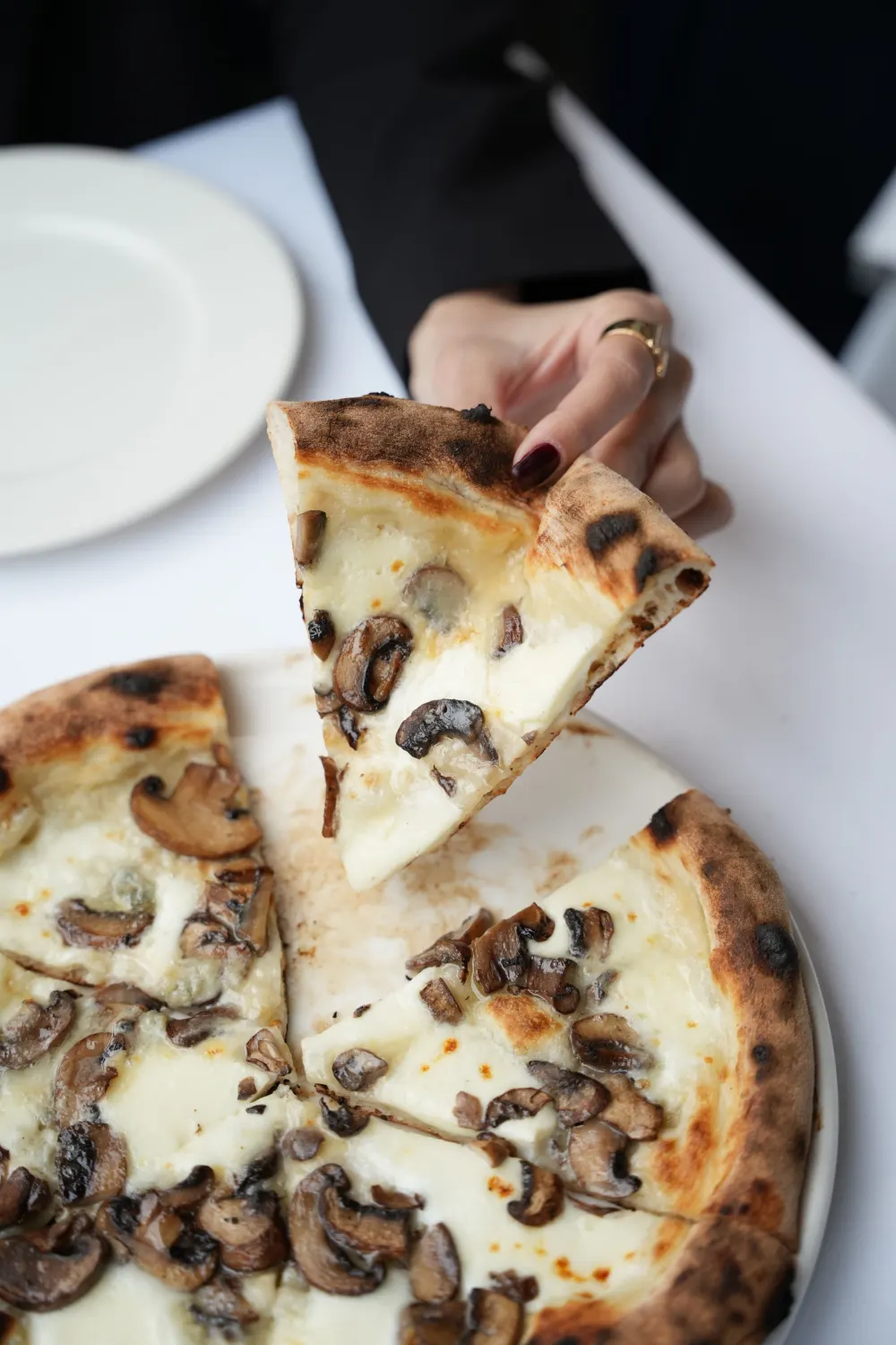 Pizza blanche aux champignons et truffe, part soulevée
