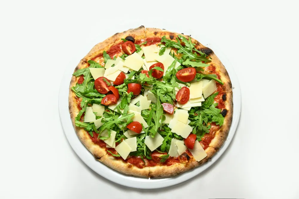Pizza végétarienne roquette, tomates cerises et copeaux de parmesan