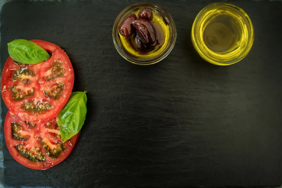 Olives, origan et huile d’olive sur une ardoise sombre
