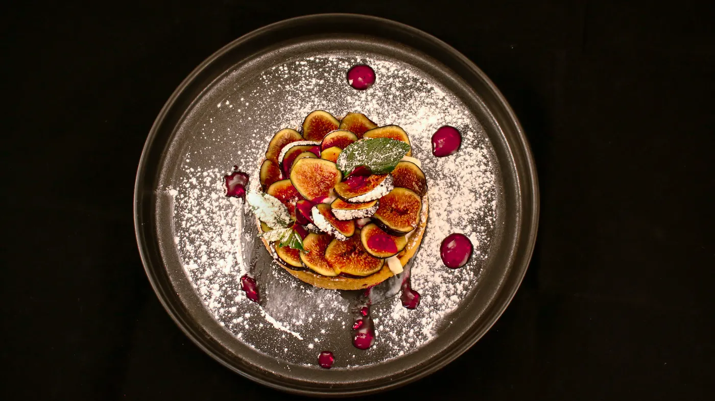 Tarte fine aux figues sur une assiette sombre