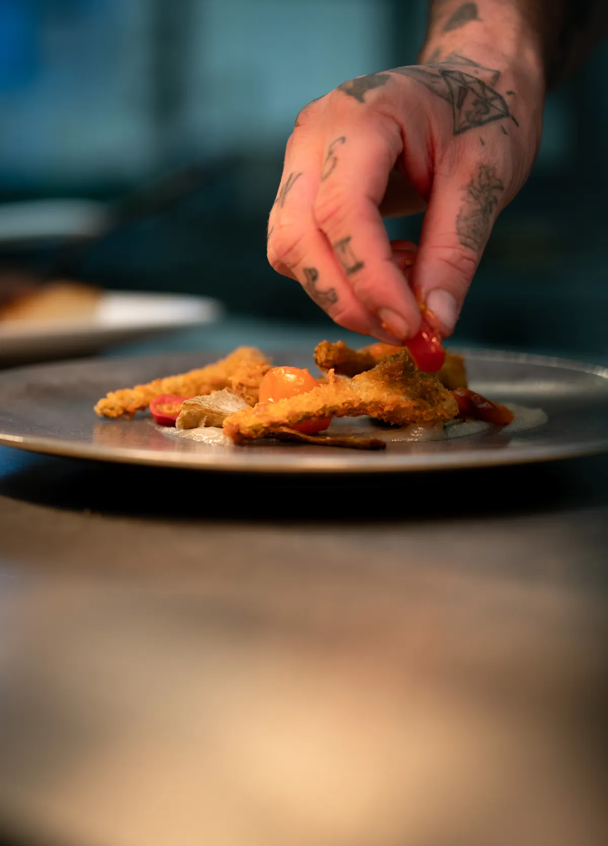 La main du chef termine une assiette
