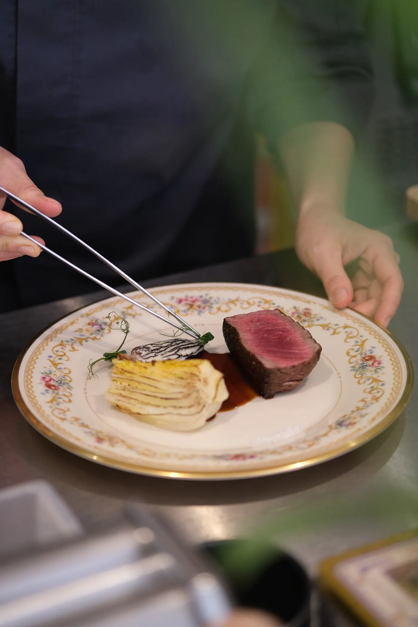 Le chef dresse une assiette à la pince