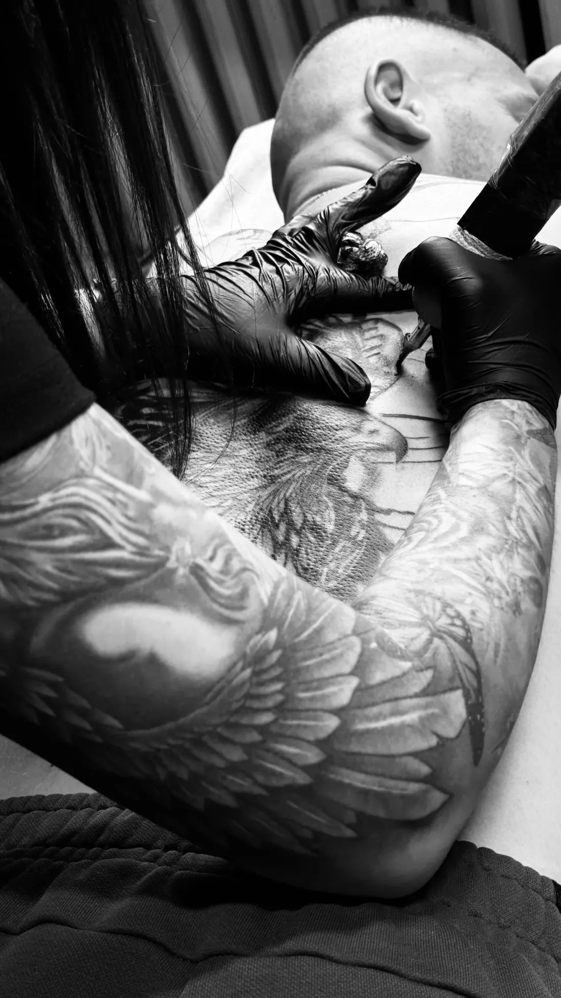 Ailes réalistes en noir et gris sur un bras en cours de tatouage