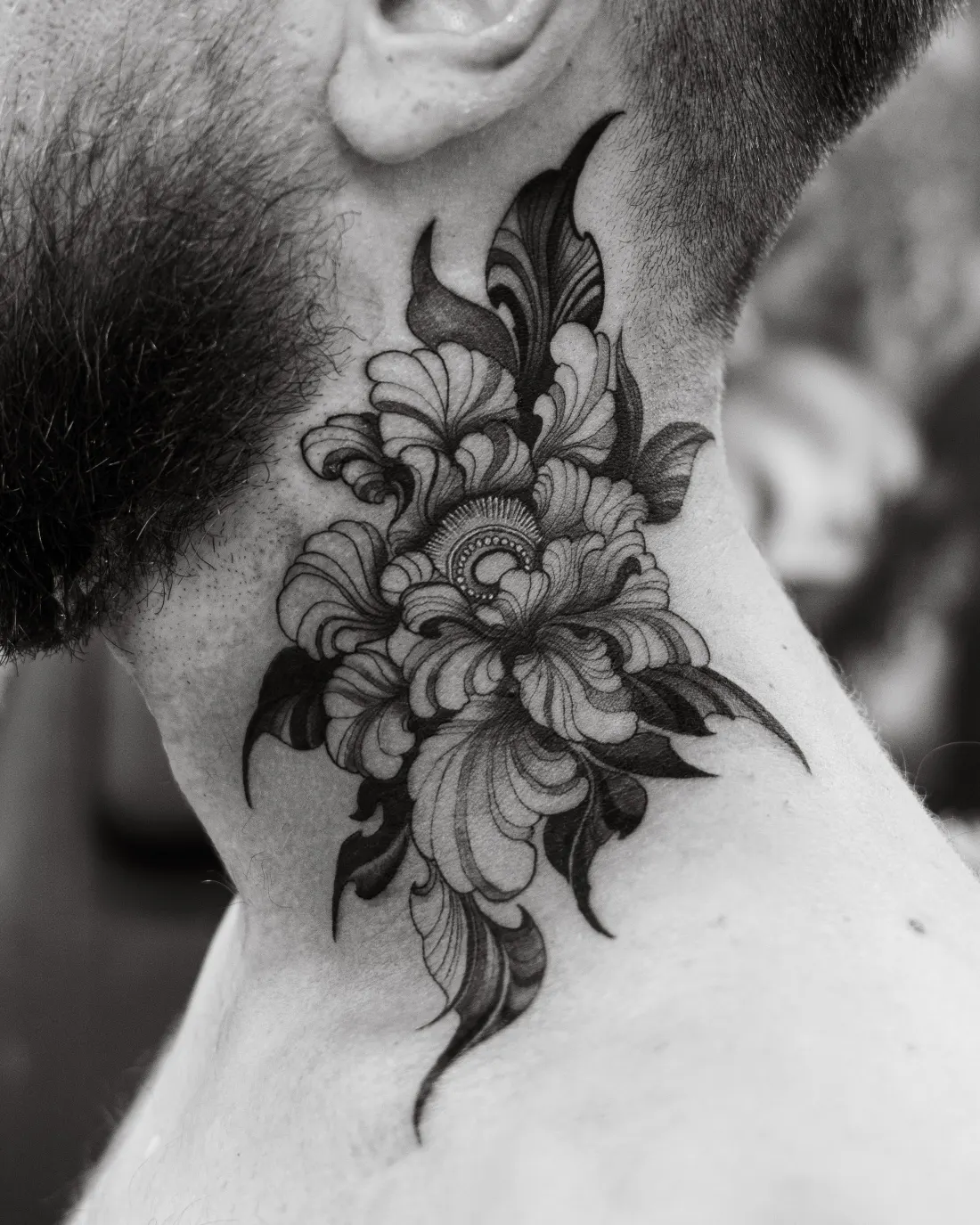 Pivoine en trait fin et ombrages sur le côté du cou d’un homme, noir et blanc