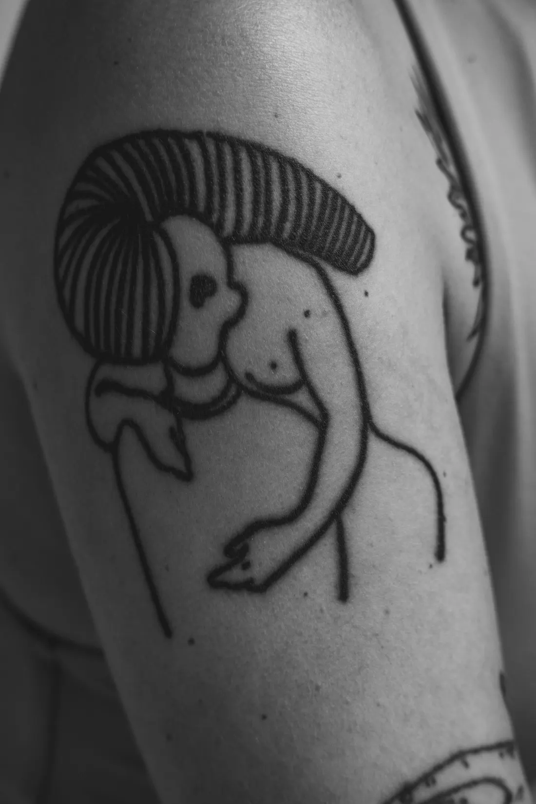 Figure abstraite au trait noir épais sur le bras, photo en noir et blanc