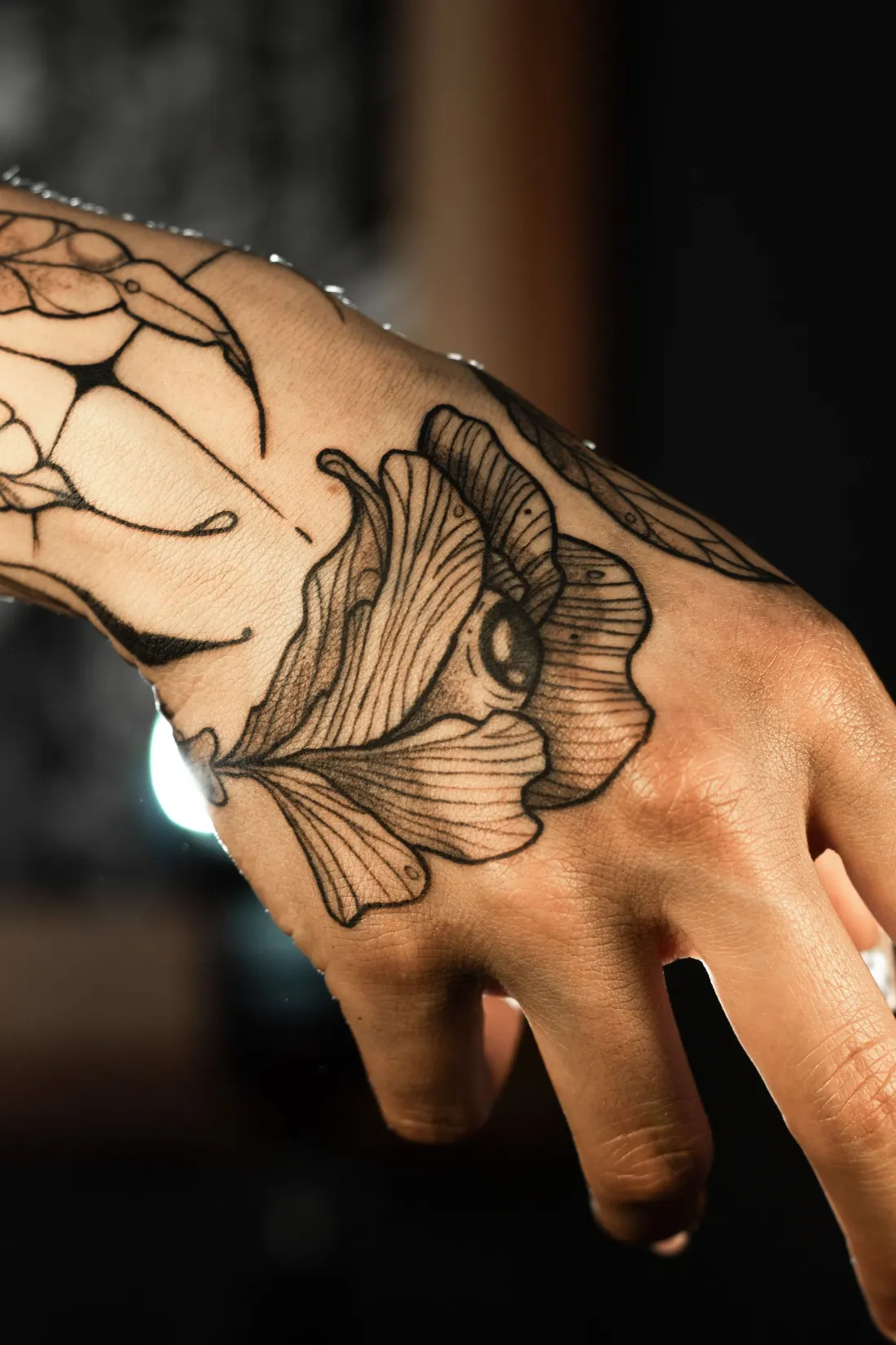 Feuille de ginkgo et toile graphique en noir sur le dos de la main