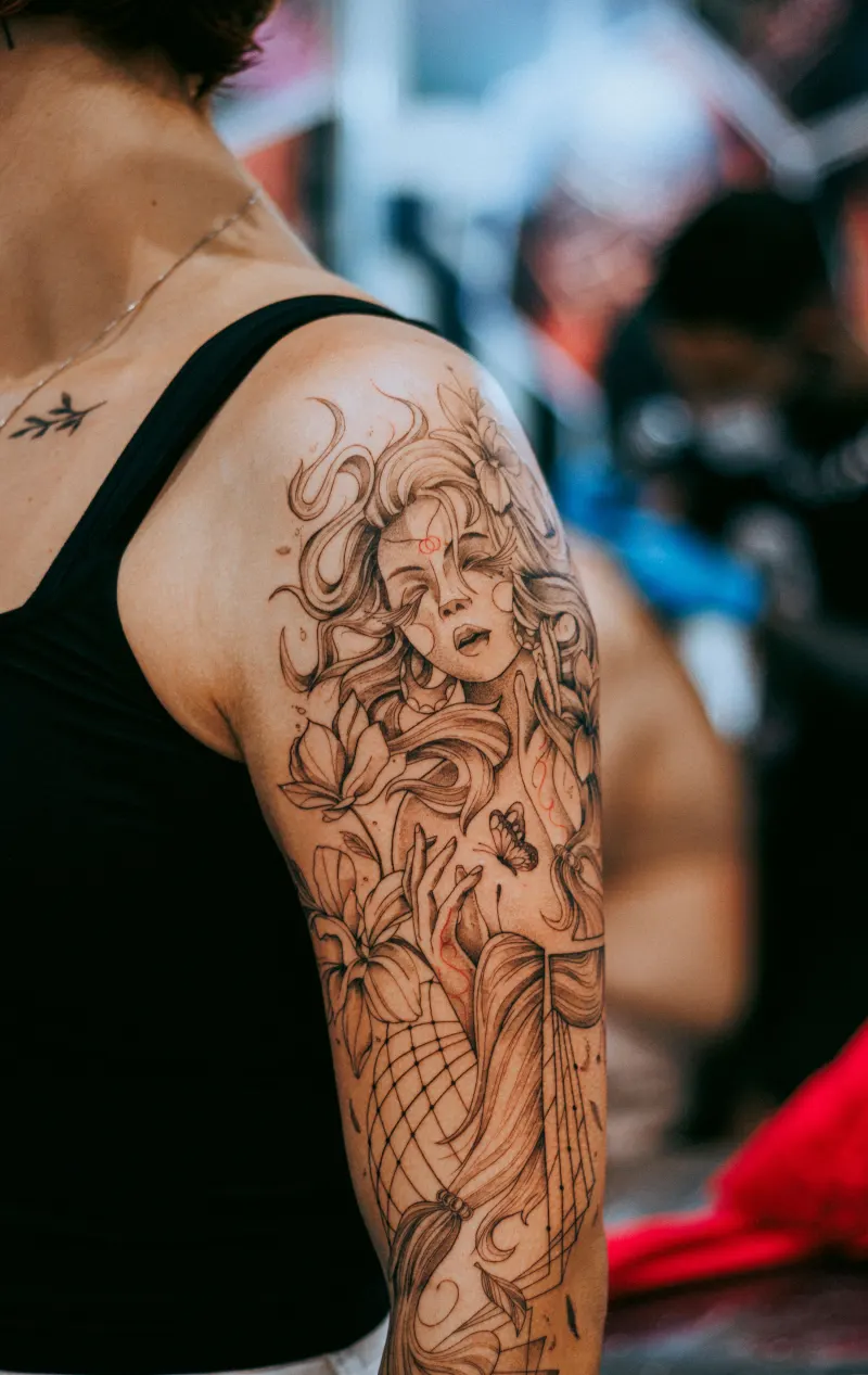 Portrait de femme entouré de fleurs sur le haut du bras