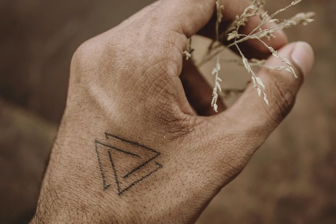 Triangle impossible de Penrose en trait fin sur le dos de la main