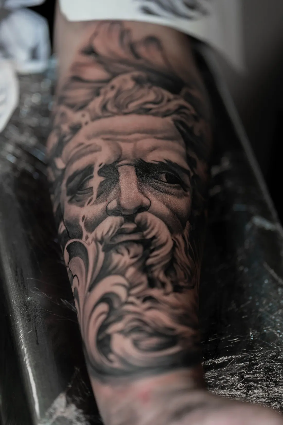 Portrait réaliste de Zeus en noir et gris sur l’avant-bras
