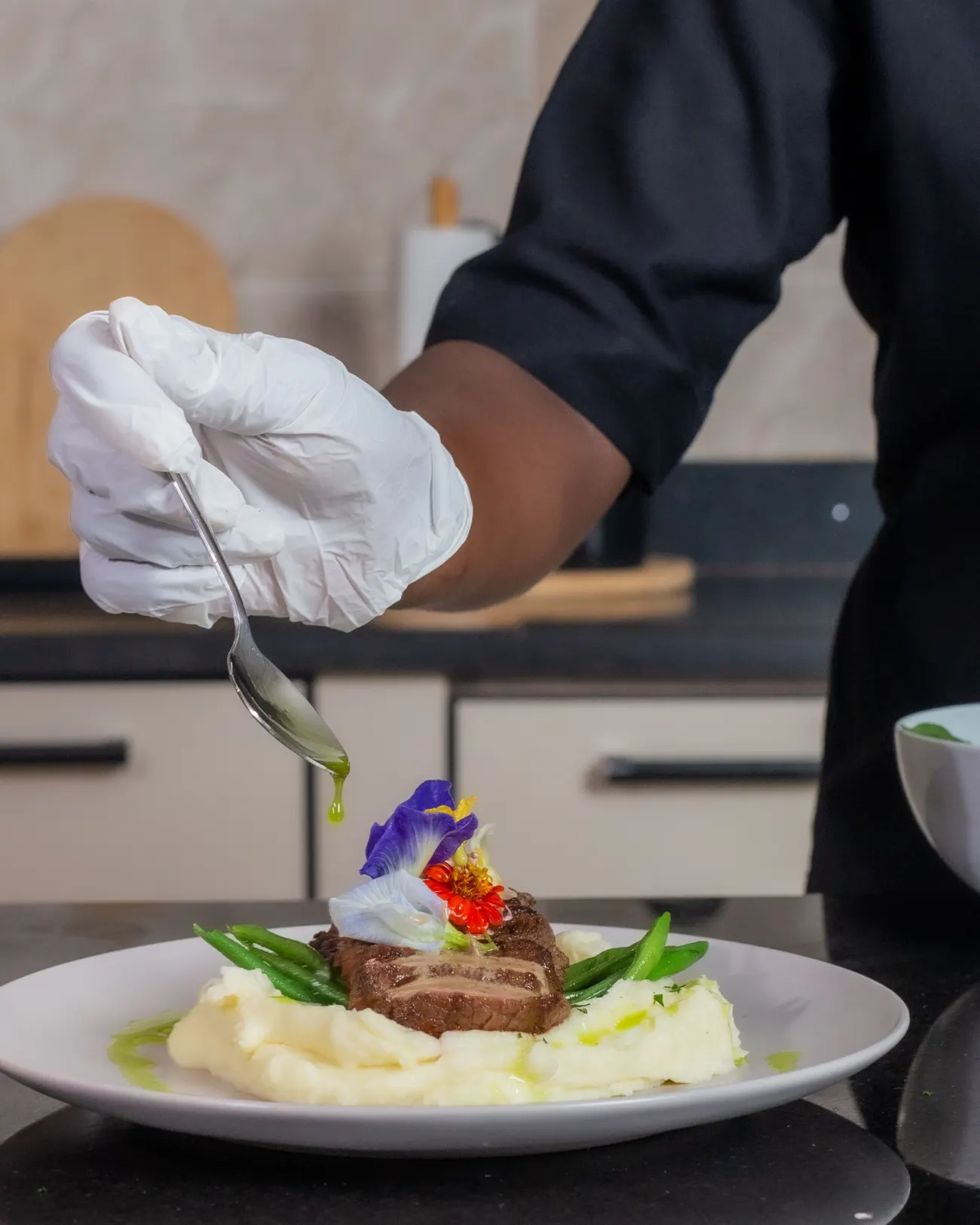 Chef qui termine un plat chez des particuliers