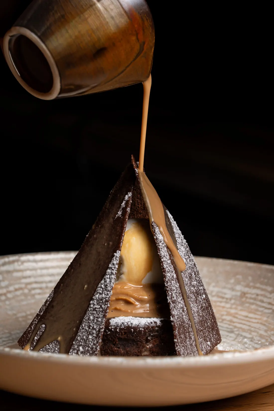 Dessert au chocolat en forme de tuile nappée, sauce versée à table