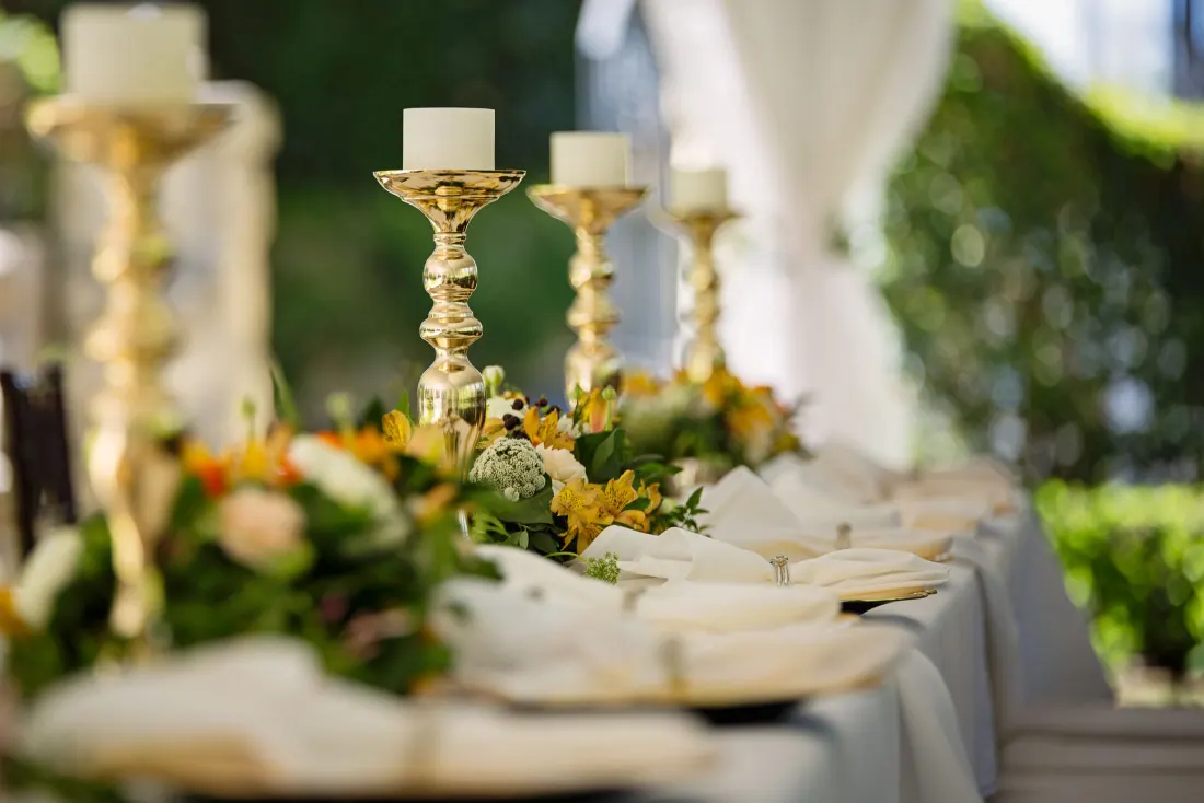 Bougeoirs dorés et fleurs sur une table de réception